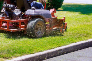 Riding mower residential lawn near a curb along the road